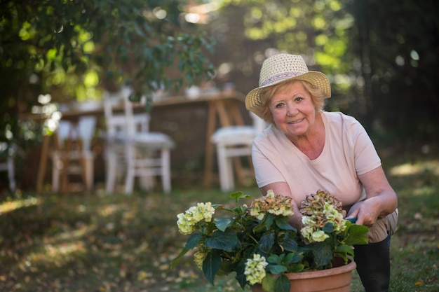 Personne agee, femme, Porter, pot, plante, jardin