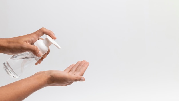 Photo personne à l'aide de l'espace de copie de gel désinfectant pour les mains