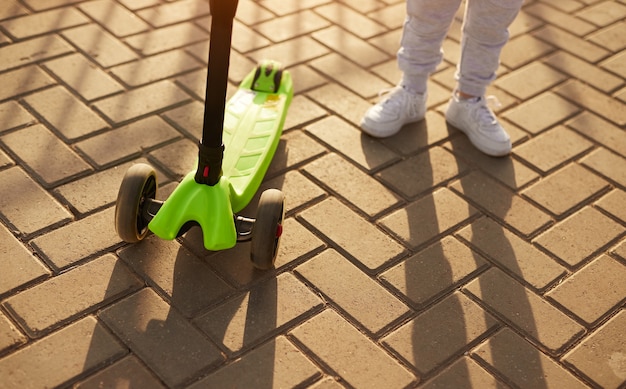 Personne anonyme debout près d'un scooter électrique