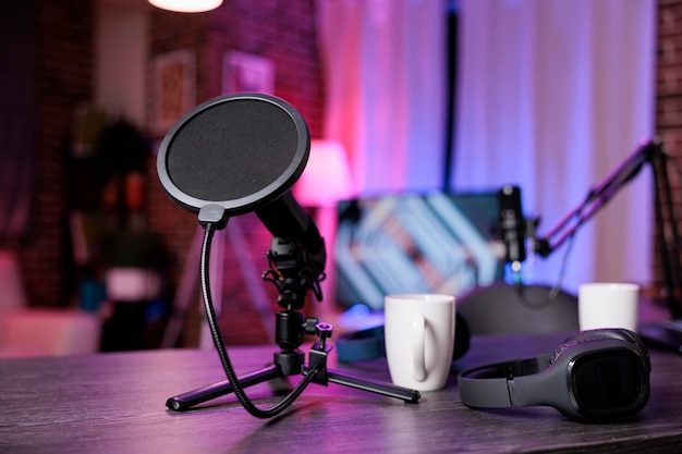 Photo personne au bureau vide avec équipement d'enregistrement pour diffuser une conversation en direct sur les réseaux sociaux. personne dans l'espace avec station de podcast, microphone et casque, production sonore.