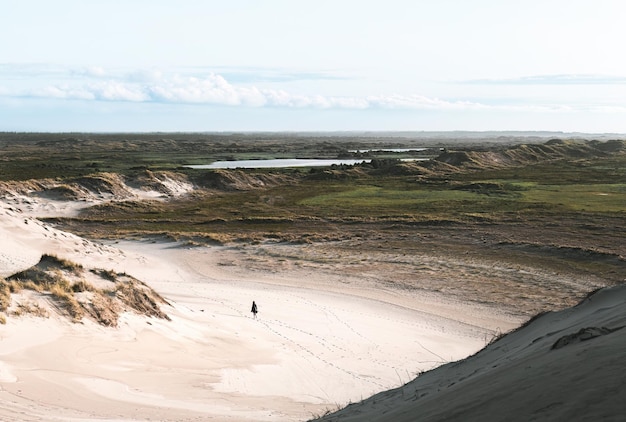 une personne au loin sur les dunes de sable de Rabjerg Mile à l'horizon à Skagen au Danemark