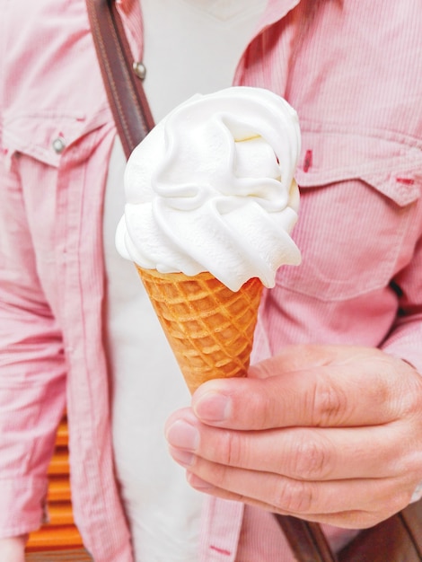 personne avec une chemise rouge tenant un cornet de gaufres avec de la glace