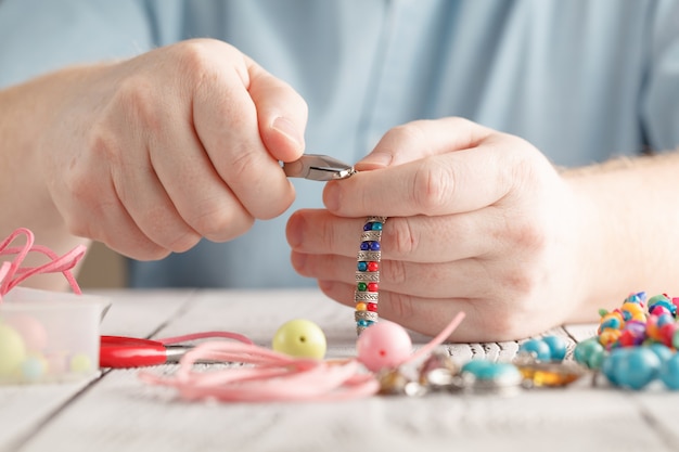 Personne, confection, boucles d'oreilles, coloré, perles, aiguilles