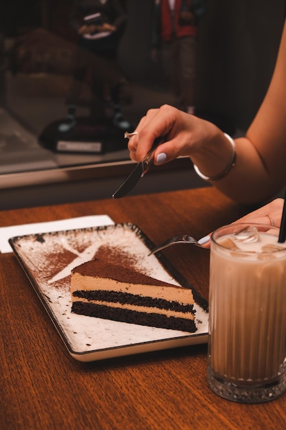 une personne coupe un morceau de gâteau avec une cuillère