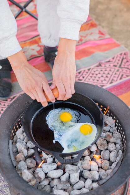 Photo personne cuisinant au feu de camp