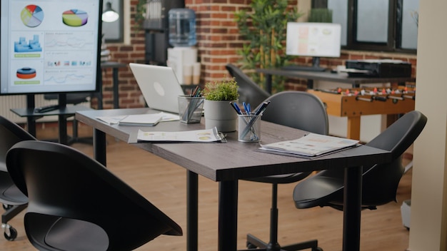 Personne dans un bureau d'affaires décoré pour une réunion de travail avec des gens. Espace de démarrage vide avec ordinateur pour planifier le projet et la stratégie marketing, salle de conférence avec ordinateur sur le bureau et décorations.