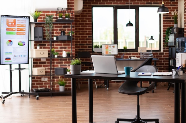 Photo personne dans le bureau de démarrage avec de l'équipement et du mobilier pour les entreprises. salle de réunion vide avec ordinateur portable et ordinateur, utilisée pour les réunions et les conférences dans l'espace d'une société financière. concept de travail