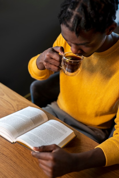 Photo personne dans un café lisant un livre