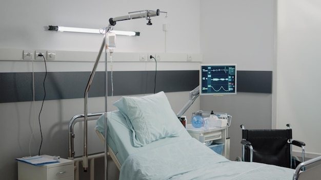 Personne dans la salle d'hôpital avec du matériel médical pour la récupération. Salle d'urgence vide avec moniteur de fréquence cardiaque, tube à oxygène et sac d'égouttement IV pour les soins de santé dans l'établissement. Espace pour soins intensifs