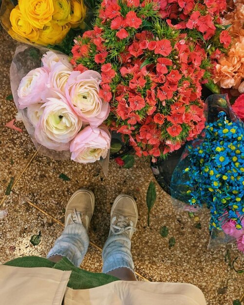 Une personne debout devant un bouquet de fleurs