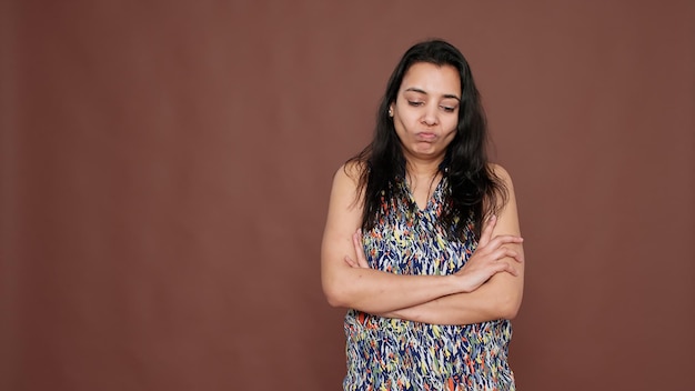 Personne déçue secouant la tête en signe de désapprobation devant la caméra, exprimant une expression faciale négative et rejetant l'information. Montrant le déni et la déception, les bras croisés.