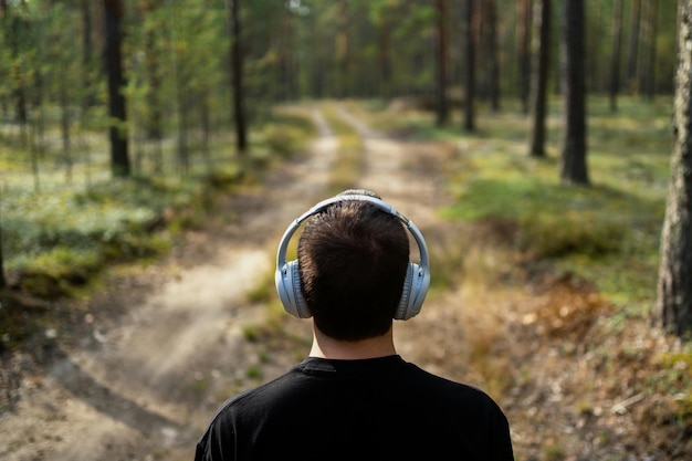 La personne écoute un livre audio Musique calme et relaxante avec des écouteurs se tient avec son dos