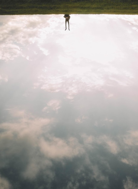 Photo personne à l'envers sur la terre contre le ciel