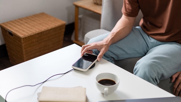 personne essayant de recharger son smartphone sur le chargeur de batterie sans fil