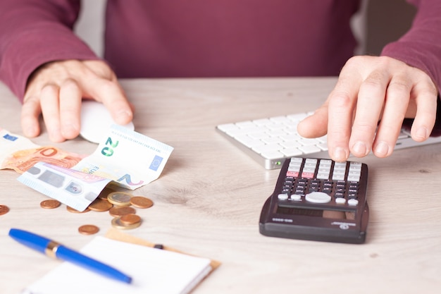 Personne faisant des calculs avec une calculatrice à une table de bureau