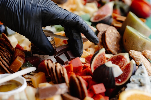 Une personne en gants noirs met la table avec un apéritif