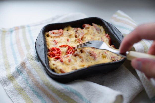 La personne goûte les plats de fromage et de tomates dans un plat sur une serviette avec une fourchette. Mise au point sélective sur l'escalade