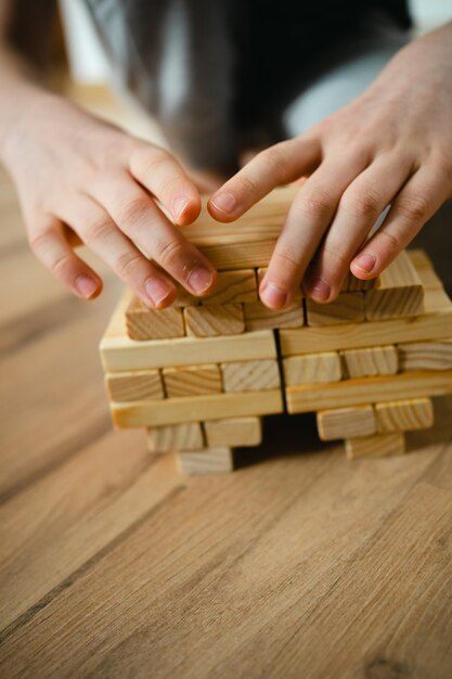 Photo personne gros plan empile des blocs de bois du concepteur sur le sol les mains des enfants jeux de société e