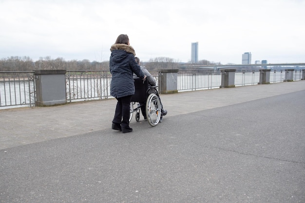 Photo une personne handicapée sur un fauteuil roulant en promenade