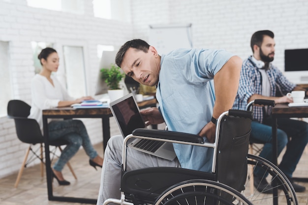 Une personne handicapée en fauteuil roulant travaille au bureau.
