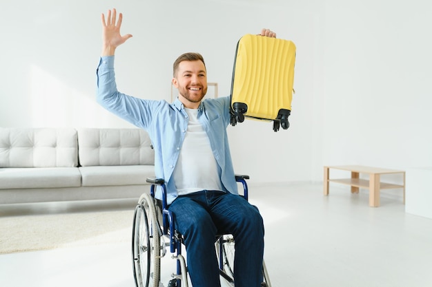 Une personne handicapée à la maison avec une valise se prépare pour les vacances Concept de loisirs