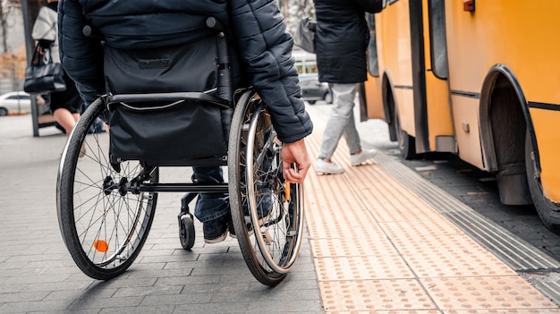 Personne handicapée physique en attente d'un transport urbain avec une rampe accessible