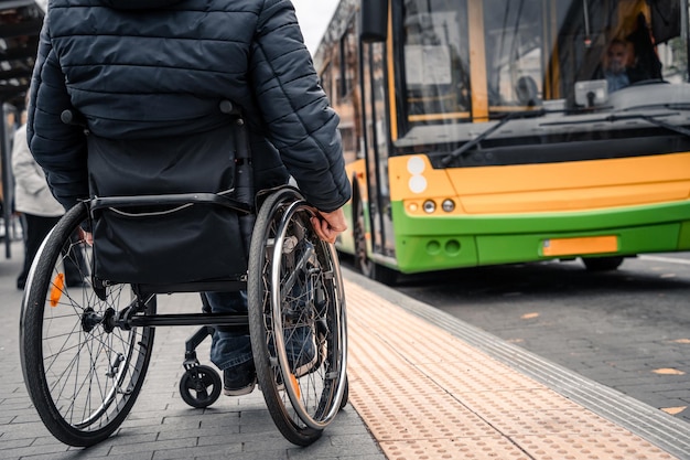 Personne handicapée physique en attente d'un transport urbain avec une rampe accessible