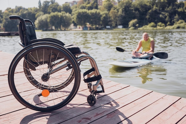 Une personne handicapée physique monte à bord du sup