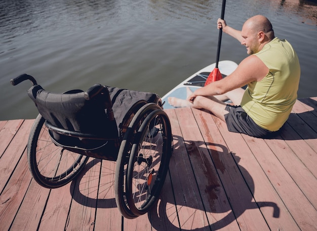 La personne handicapée physique qui utilise un fauteuil roulant sera montée sur un sup board