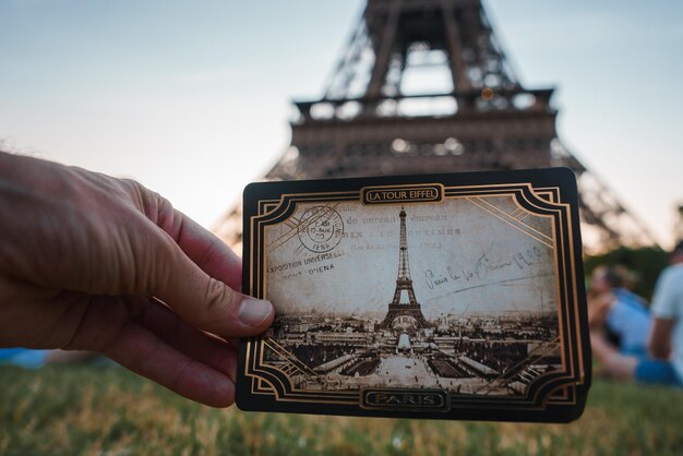 Photo personne heureuse tenant la photo de la tour eiffel