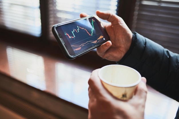Personne investissant sur le marché boursier de la crypto-monnaie à l'aide d'une application d'investissement sur smartphone
