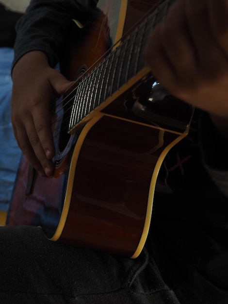 Une personne jouant de la guitare avec une guitare