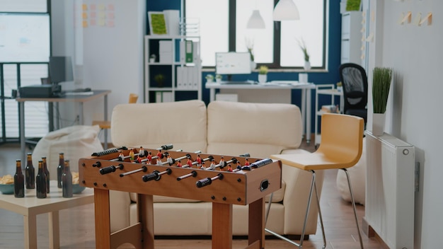 Personne sur le lieu de travail pour les hommes d'affaires se réunissant après le travail pour prendre un verre et faire la fête. Bureau vide avec table de football, collations et bouteilles avec boissons alcoolisées pour le plaisir