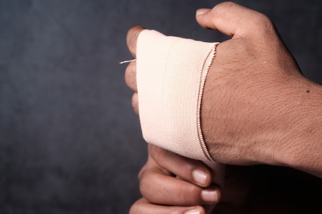 Personne mains avec un bandage de gaze enroulé autour