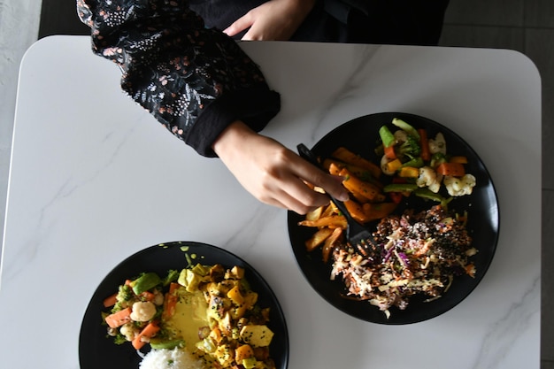 Une personne mange un repas avec une fourchette et un couteau.