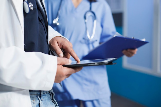 Une personne avec un manteau de laboratoire tenant une tablette