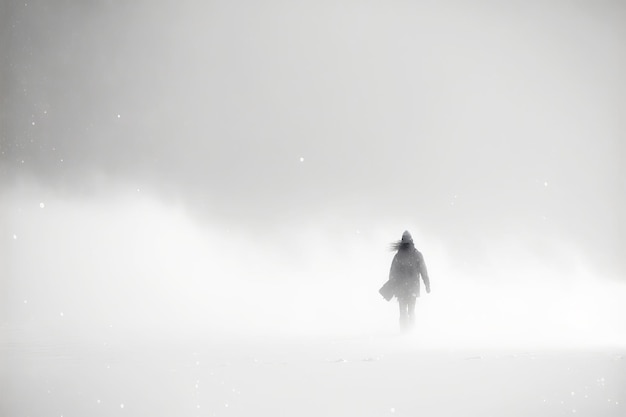Personne marchant dans une tempête de neige hivernale AI générative