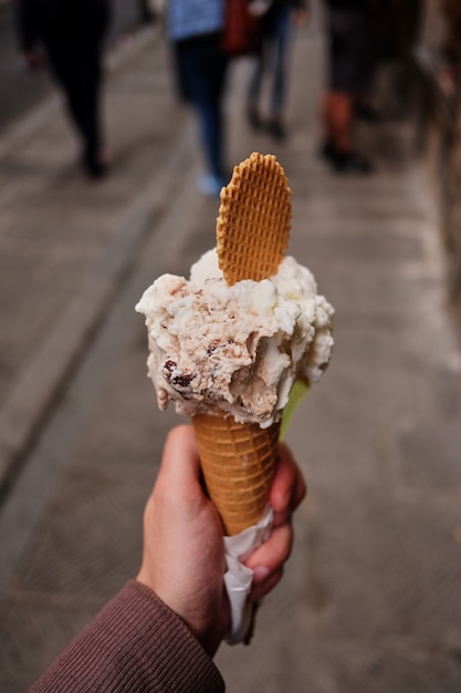 personne marchant le long de la route avec une glace au chocolat