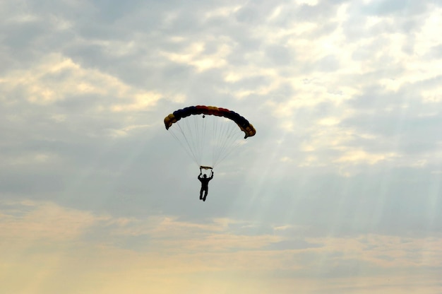 Personne en parapente contre un ciel nuageux