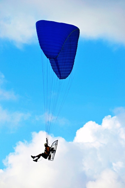Personne en parapente à moteur contre le ciel