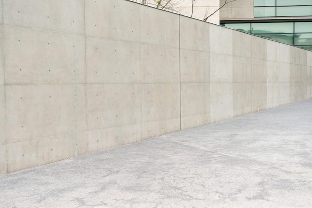 personne photo d'un mur de béton gris vide à l'extérieur au bureau du bâtiment moderne des fenêtres de réflexion à l'extérieur dans une ville prospère avec des trottoirs en arrière-plan.