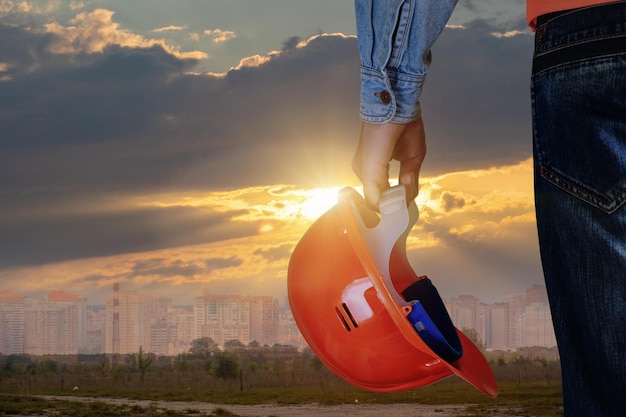 Une personne portant un casque le tient dans le ciel.