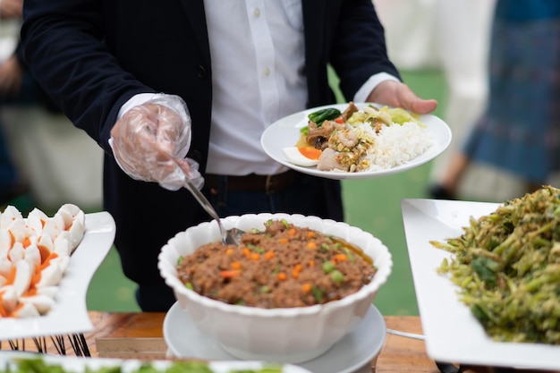 Une personne portant des gants ramassant de la nourriture, de la restauration, l'heure du dîner, prévient la maladie à coronavirus (covid 19)