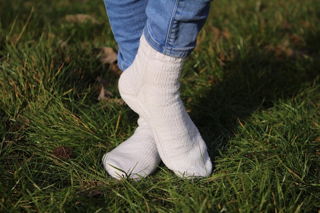 une personne portant une paire de chaussures se tient dans l'herbe