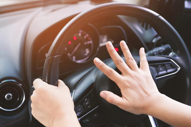 personne poussant le klaxon pendant la conduite assise d'un volant appuyez sur le son de la voiture pour avertir les autres personnes dans le concept de circulation