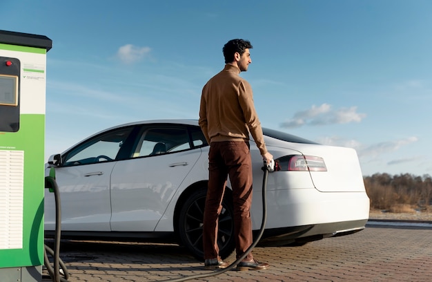 Photo personne prenant soin de la voiture électrique