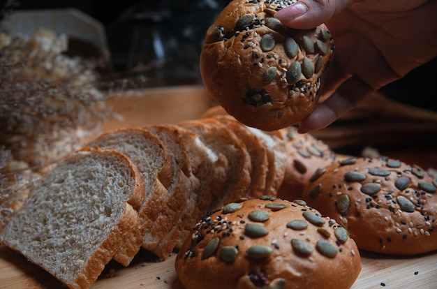 Une personne prend un morceau de pain sur une table.