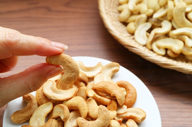 Personne qui choisit une noix de cajou rôtie de Snack Saucer