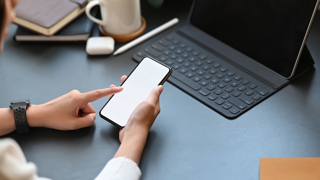 Personne recadrée à l'aide de smartphone sur tableau noir.