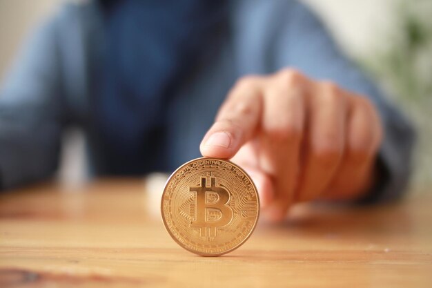 Une personne roulant la crypto-monnaie Bitcoin sur la table concept d'investissement d'actifs numériques